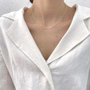 Close-up of a minimalist 925 sterling silver twisted chain necklace worn by a model