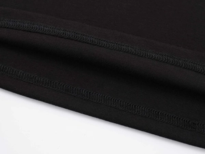 Vue macro des coutures de l'ourlet sur le T-shirt noir en modal avec col en V
