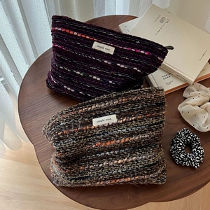 Close-up of woven wool tweed makeup bags with zippers and simple wish labels