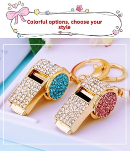Detail of crystal whistle keychains in gold finish with blue and rose pink rhinestones