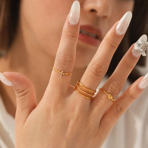 Gold layered ring set with cross zirconia and heart accent on a female hand model
