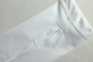 Macro shot of white cooling arm sleeves showing thumb hole stitching and elastic fabric texture