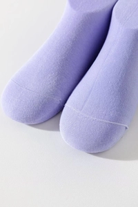 Dettaglio macro della maglia fine e della cucitura sulle dita di calze in cotone viola