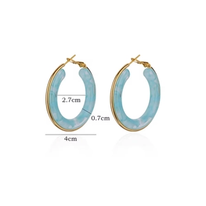 Vue détaillée des boucles d'oreilles en résine en C avec texture marbre bleu et métal doré