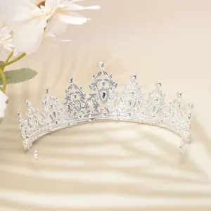Detailed side view of silver luxury crown with intricate cutouts and sparkling rhinestones