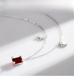 Macro detail of S925 silver necklace featuring a vivid red rectangular gemstone pendant