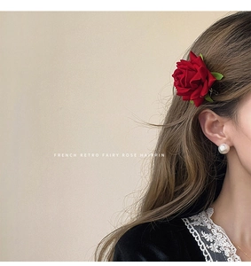 Close-up of red velvet rose hairpin worn by a model in a French retro fairy style