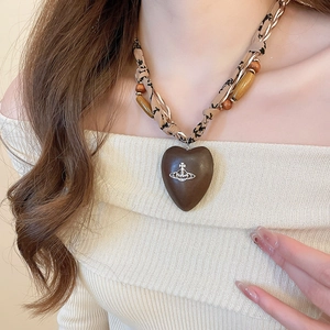 Ethnic heart pendant necklace with wood beads and Saturn logo on floral fabric cord