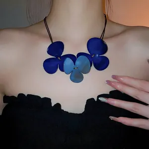 Three-leaf blue floral pendant necklace with matte resin petals on a dark cord cord