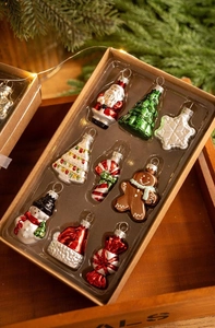 Detailed set of 9 festive glass Christmas ornaments in a gift box with warm lighting