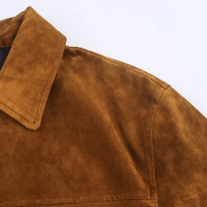 Gros plan détaillé d'une veste en daim marron montrant le revers et les coutures