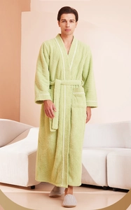 Detail of light green bathrobe with white piping trim and plush fabric texture