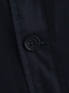 Close-up of navy blue twill jacket fabric texture with a black resin button detail