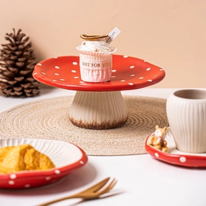 Macro shot of a red polka dot mushroom ceramic cake stand with forest props