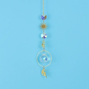 Detail of golden sun catcher featuring faceted crystal ball and celestial fairy pendants