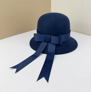 Detail of navy wool cloche hat featuring an elegant ribbon bow and long flowing streamers