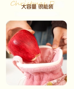 Pink plush Christmas gift bag with sequins being filled with a red apple for storage