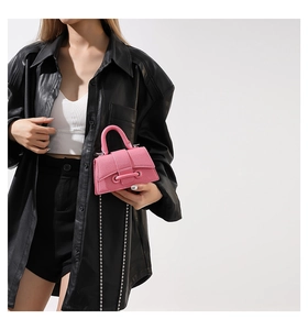 Detail of pink mini handbag featuring lychee pattern leather and silver chain strap