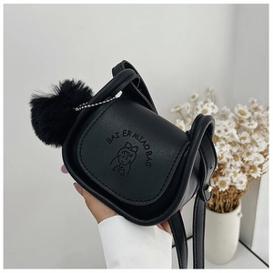 Detail of mini black crossbody bag with embossed cartoon character and plush ball charm