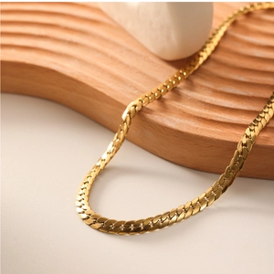 Close-up of flat 18k gold plated stainless steel snake chain necklace on wooden stand