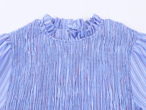 Détail du chemisier à rayures bleues avec texture froncée en nid d'abeille