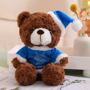 Brown teddy bear wearing blue Christmas hat and snowflake sweater for holiday decoration