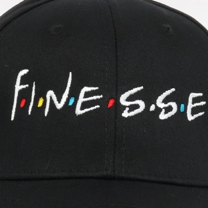 Close-up of Finesse embroidery on black cotton baseball cap with colorful dots detail