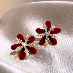 Elegant red flocked flower earrings with pearls and crystals on a luxury satin background