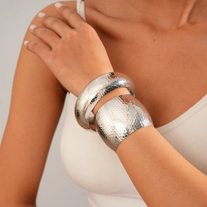 Close-up of three-piece silver metal bangles with handcrafted hammered texture on wrist