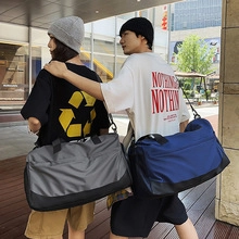 Outdoor street scene showcasing large nylon travel bags in gray and blue with shoulder straps