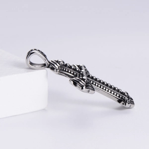 Detail of vintage gothic cross pendant showing intricate embossed textures and 3D metal carving