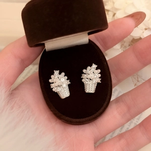 Close-up of elegant flower basket earrings with zircons and pearls in a brown gift box