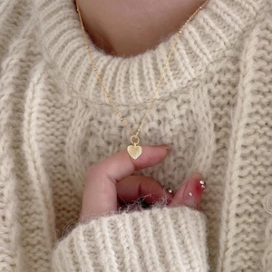 Elegant 925 sterling silver heart pendant necklace with gold texture on beige knit sweater