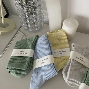 Detailed knit texture of colorful confetti cotton socks with elegant paper packaging