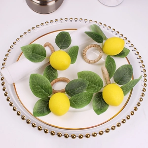 Detailed view of four lemon napkin rings with green leaves on a white beaded dinner plate