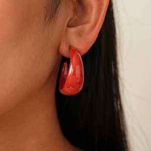 Close-up of a model wearing a glossy deep red acrylic geometric thick hoop earring