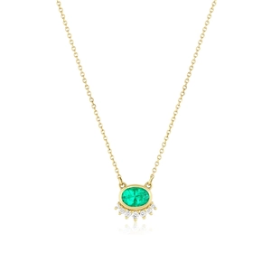 Detailed macro view of the gold oval emerald pendant with small sparkling diamonds