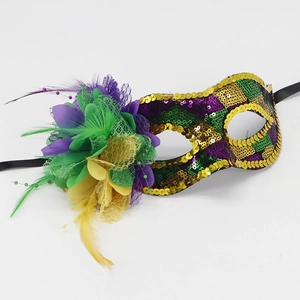 Detail of Mardi Gras masquerade mask with purple green gold sequins and soft feathers