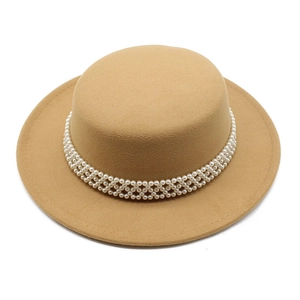 Macro view of woven pearl band decoration on a beige wool boater hat for women
