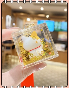 Detailed view of Maneki Neko keychain featuring golden glitter and acrylic oil design