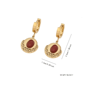 Detailed view of gold earrings with red oval stones and dimension measurements