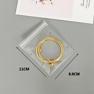 Detail showing 11cm x 8.8cm frosted jewelry pouch holding golden charm bracelets