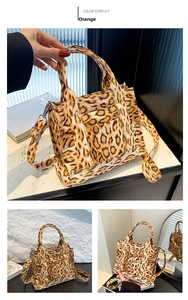 Detail view of leopard print crossbody bag in orange color with stylish top handles