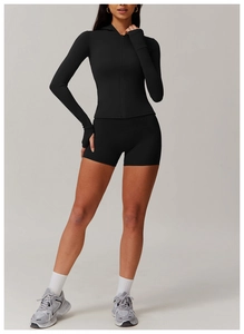 Detail of black hooded zip-up sports top with thumbholes and high waist gym shorts