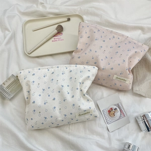 Detailed view of floral cotton makeup pouches with zip closure in an aesthetic setup