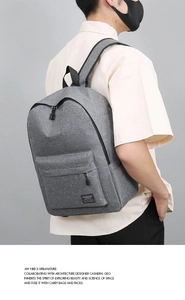 Rear view of model wearing a grey durable travel backpack with Fashion label