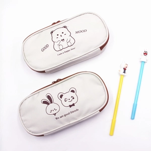 Close-up of canvas pencil cases with bear illustrations and brown zipper details