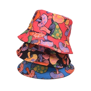Dettaglio di tre cappelli a secchiello reversibili con stampe di funghi colorati in vari colori