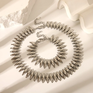 Ensemble collier et bracelet lune en argent poli sur une élégante surface blanche texturée