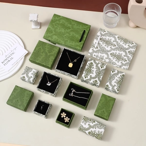 Detailed set of dark green paisley pattern jewelry boxes and matching gift bags
